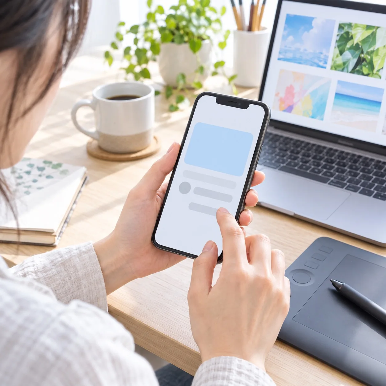 スマートフォンで依頼の画面を確かめる手元のイメージ