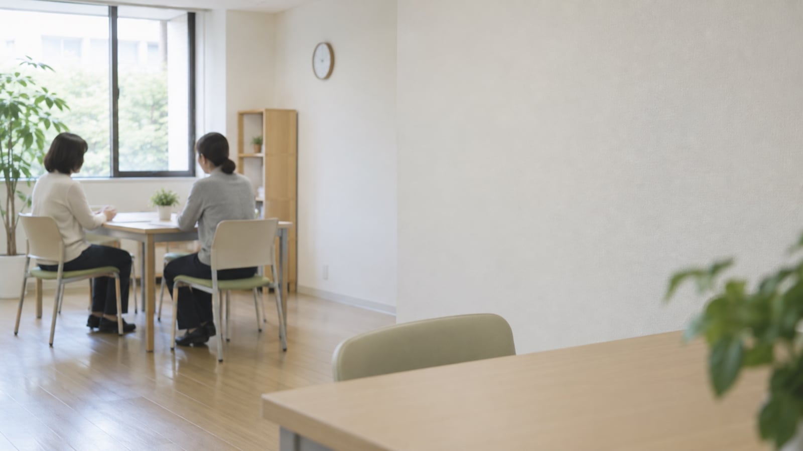 地域の相談室で二人が机越しに話す遠景